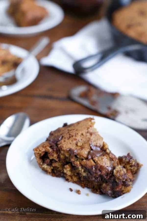 A slice of gooey Low-Fat Peanut Butter Chocolate Chip Deep Dish Skillet Cookie on a plate, showcasing its fudgy texture and melted chocolate chips.