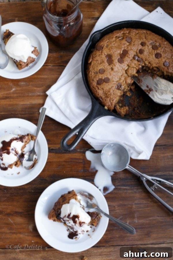 Three individual bowls filled with warm Peanut Butter Chocolate Chip Deep Dish Skillet Cookie and a scoop of vanilla ice cream, ready to be served.