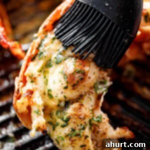 Perfect Grilled Lobster Tails 4 Grilled Lobster Tails brushed with melted garlic herb butter on a black grill pan.
