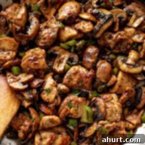 Savory Garlic Mushroom Chicken Poppers 5 Garlic Mushroom Chicken Bites cook in no time at all! An easy dinner recipe cooked in a silver pan or skillet with a wooden spoon.