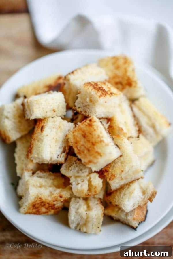 A plate piled high with golden-brown, crispy grilled cheese croutons, showcasing their perfect toast and hinting at the melted cheese inside.