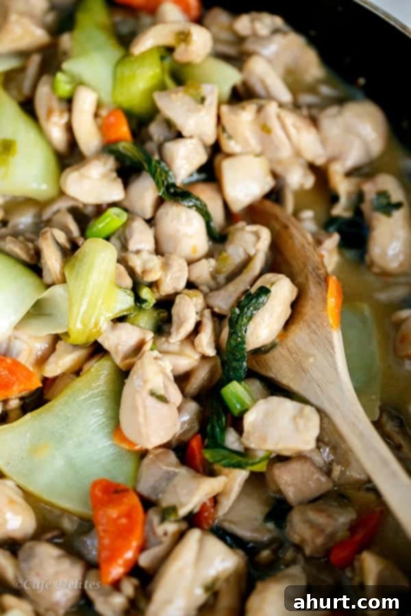 Honey Mustard Chicken Stir Fry in a serving bowl with a wooden spoon, showcasing the delicious sauce