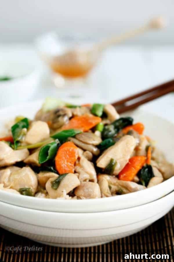 Side view of a generous serving of Honey Mustard Chicken Stir Fry in a bowl, showcasing the colorful vegetables and glistening chicken pieces