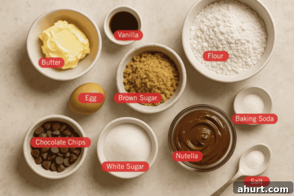 Decadent Nutella Cookie Pie 2 Labeled flatlay image of ingredients for a Nutella cookie pie. Bowls are arranged on a light surface and include butter, vanilla, flour, brown sugar, white sugar, Nutella, chocolate chips, baking soda, and salt. An egg is placed directly on the surface, and each ingredient is clearly labeled with red tags.
