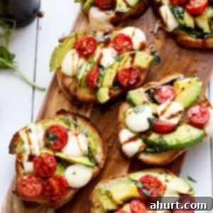 Zesty Caprese Crostini with Smoky Grilled Avocado 11 5 pieces of Avocado Caprese Crostini on a wooden tray ready to enjoy