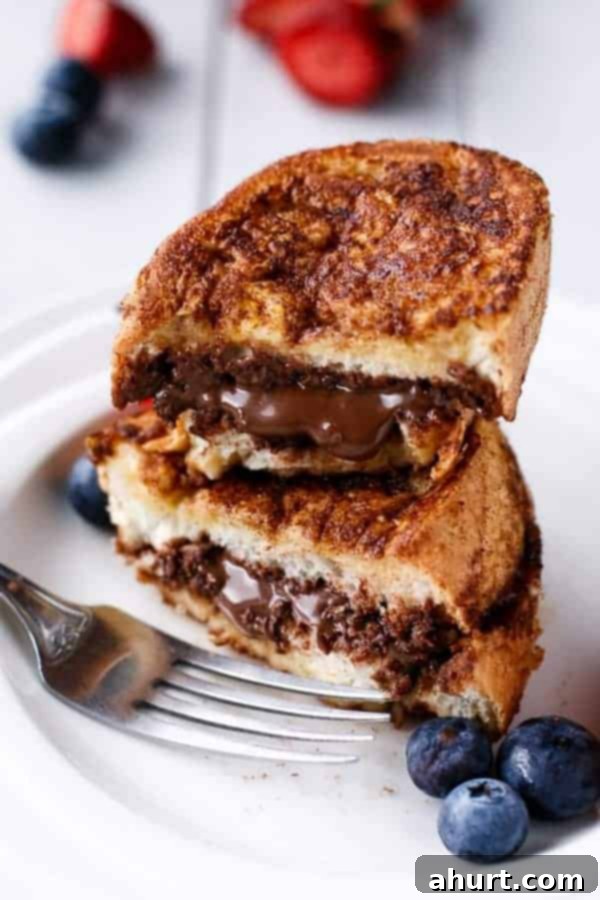 Decadent Nutella Stuffed Churro French Toast on a plate, dusted with sugar