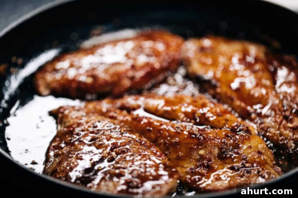Fiery Honey Glazed Chicken 7 Chicken simmering in hot honey butter sauce.