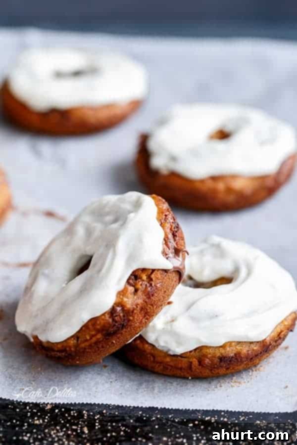 Warm Banana Bread Doughnuts, Bursting with Nutella 3 scattered cream cheese topped donuts on a plate