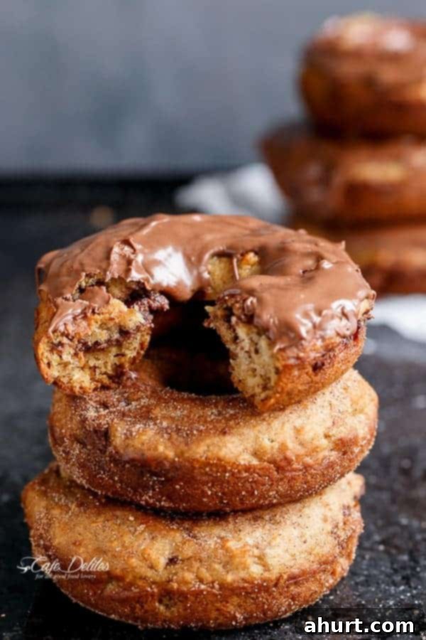 Warm Banana Bread Doughnuts, Bursting with Nutella 7 A stack of donuts with the top being covered with Nutella and a bite taken out from the top one