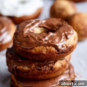 Warm Banana Bread Doughnuts, Bursting with Nutella 10 Nutella Stuffed Baked Banana Bread Donuts with Cream Cheese Frosting being stack on each other