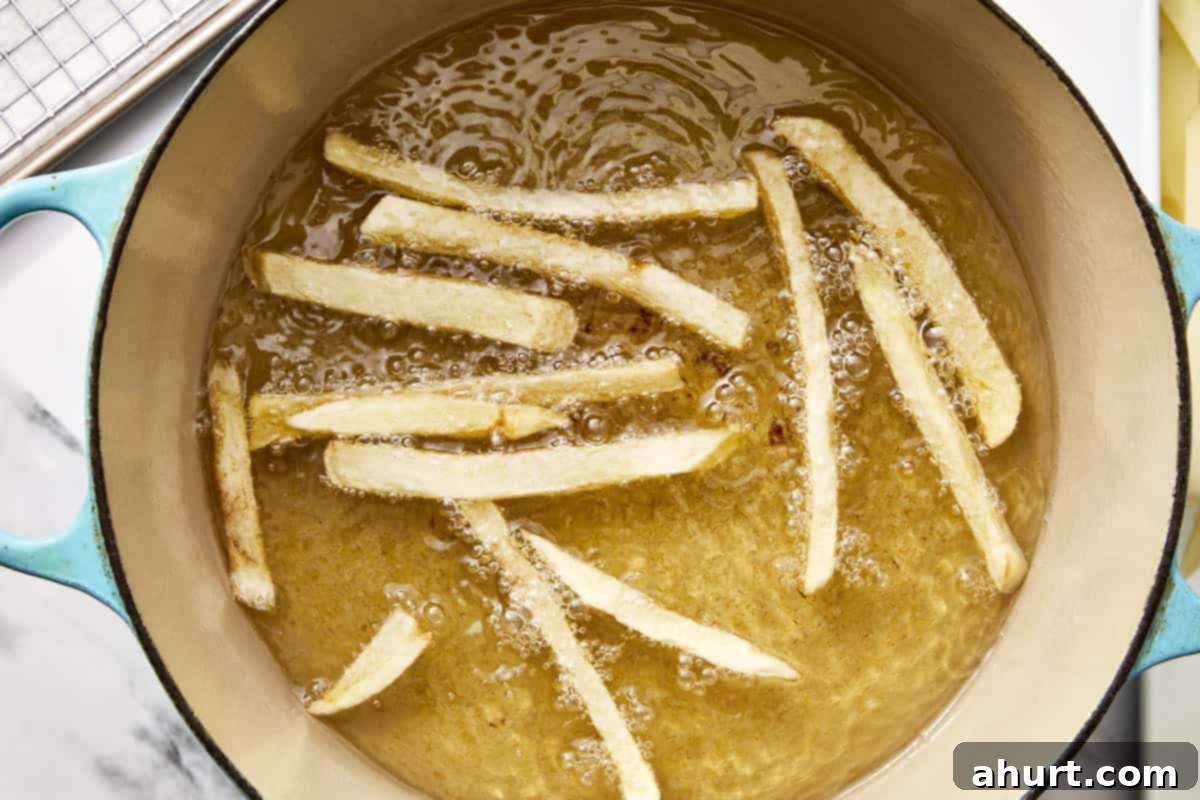 Golden Crispy Fries 6 fries being cooked in a pot with oil
