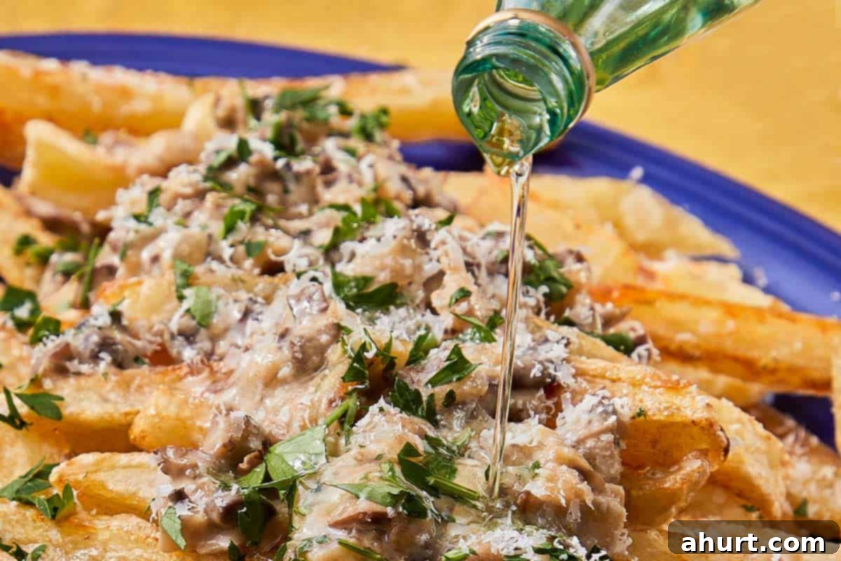 Handcrafted Truffle Fries 11 Truffle fries arranged in a baking dish, topped with mushroom sauce and Parmesan, ready for the oven to melt the cheese.