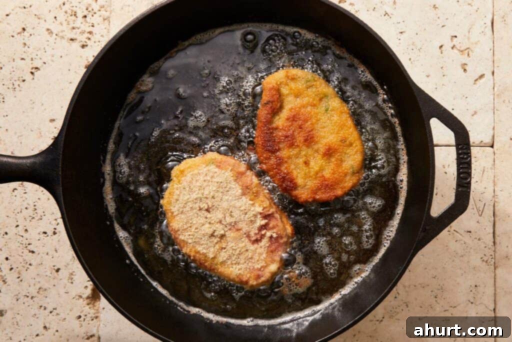 The Ultimate Beef Milanesa Experience 7 Beef milanesa frying in hot oil until golden and crispy