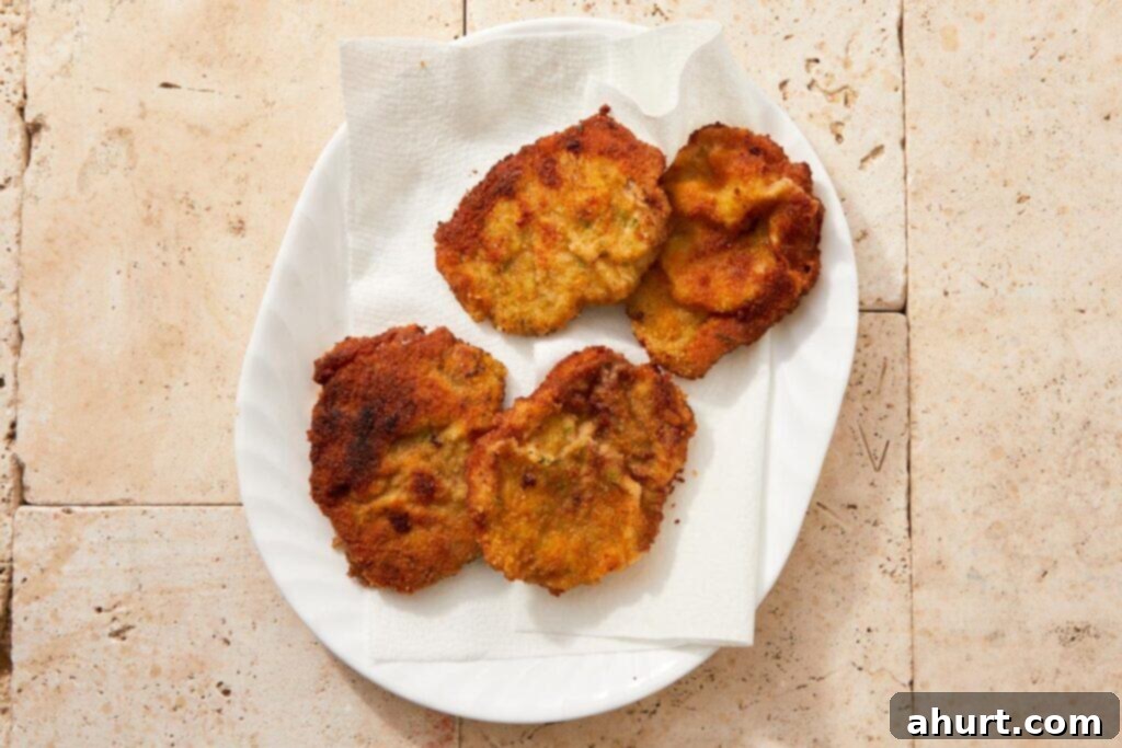 The Ultimate Beef Milanesa Experience 8 Fried beef milanesa draining on paper towels to remove excess oil
