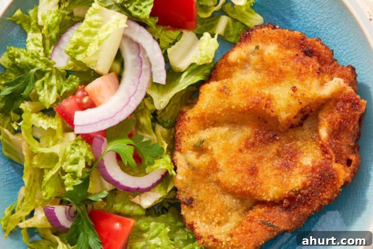 The Ultimate Beef Milanesa Experience 9 Beef milanesa plated with tomato salad.