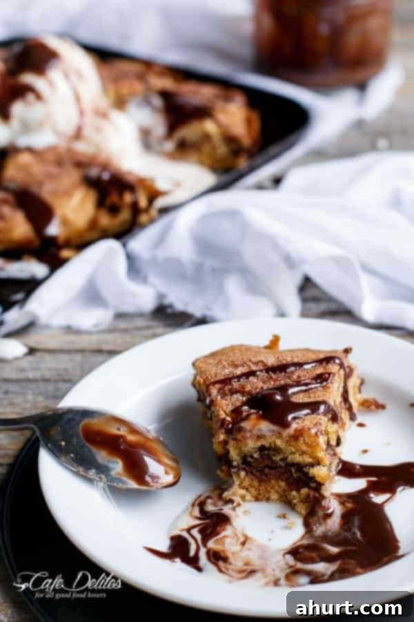 Nutella Stuffed Churro Deep Dish Skillet Cookie cut into pieces, showing gooey Nutella center