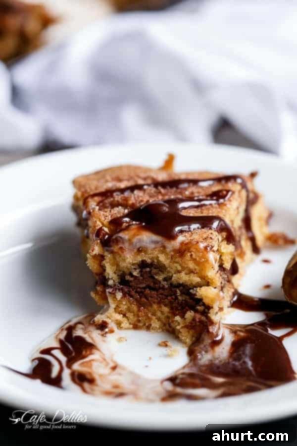 Final image of a delicious piece of Nutella Stuffed Churro Deep Dish Skillet Cookie on a plate after a bite has been taken
