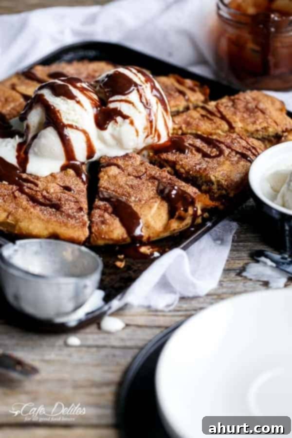 Nutella Stuffed Churro Deep Dish Skillet Cookie with a scoop of vanilla ice cream and sauce