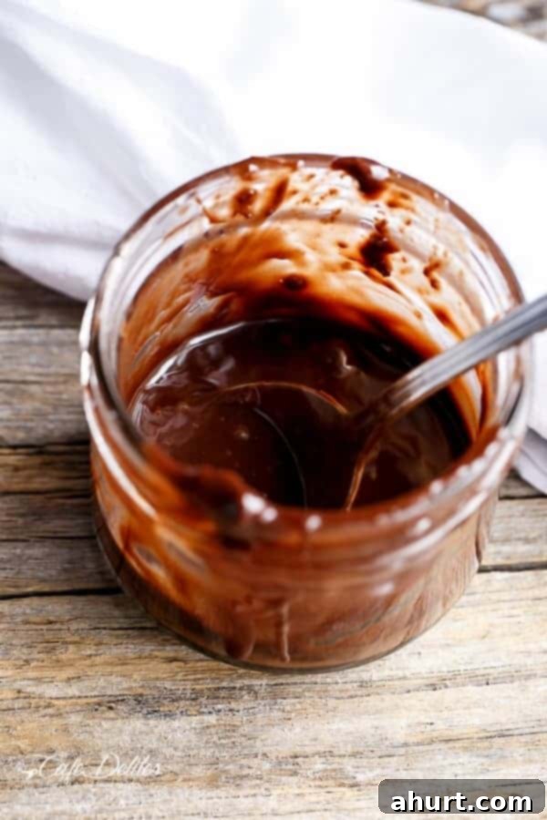 Jar of warm Nutella sauce, perfect for topping the Stuffed Churro Deep Dish Skillet Cookie