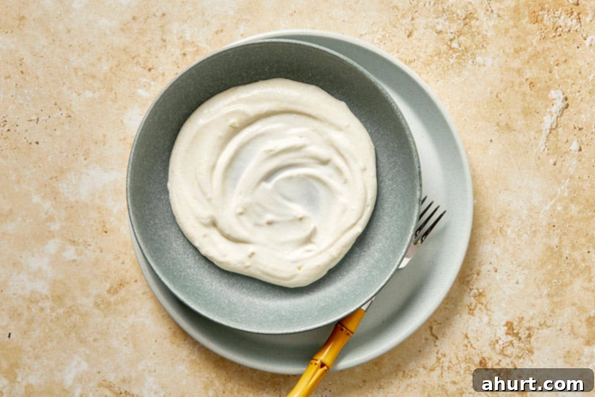 Cilbir Turkish Eggs 4 Creamy garlic yogurt spread in a shallow bowl.