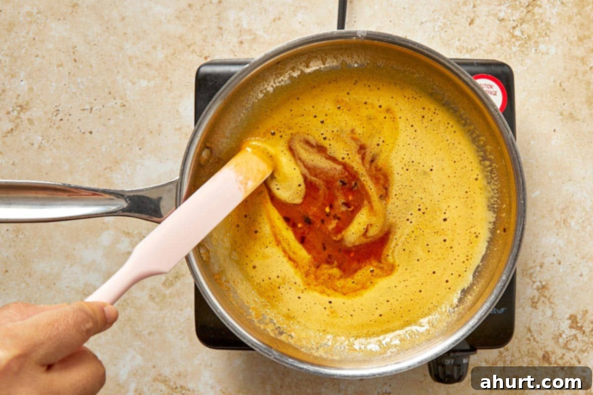 Cilbir Turkish Eggs 5 Melting butter with paprika and chili flakes in a pan.