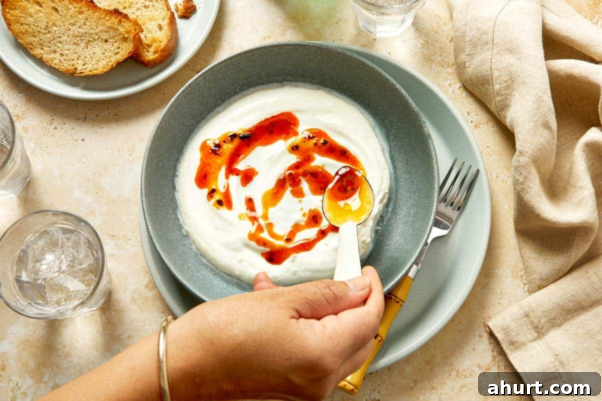 Cilbir Turkish Eggs 7 Drizzling chili butter over whipped yogurt.