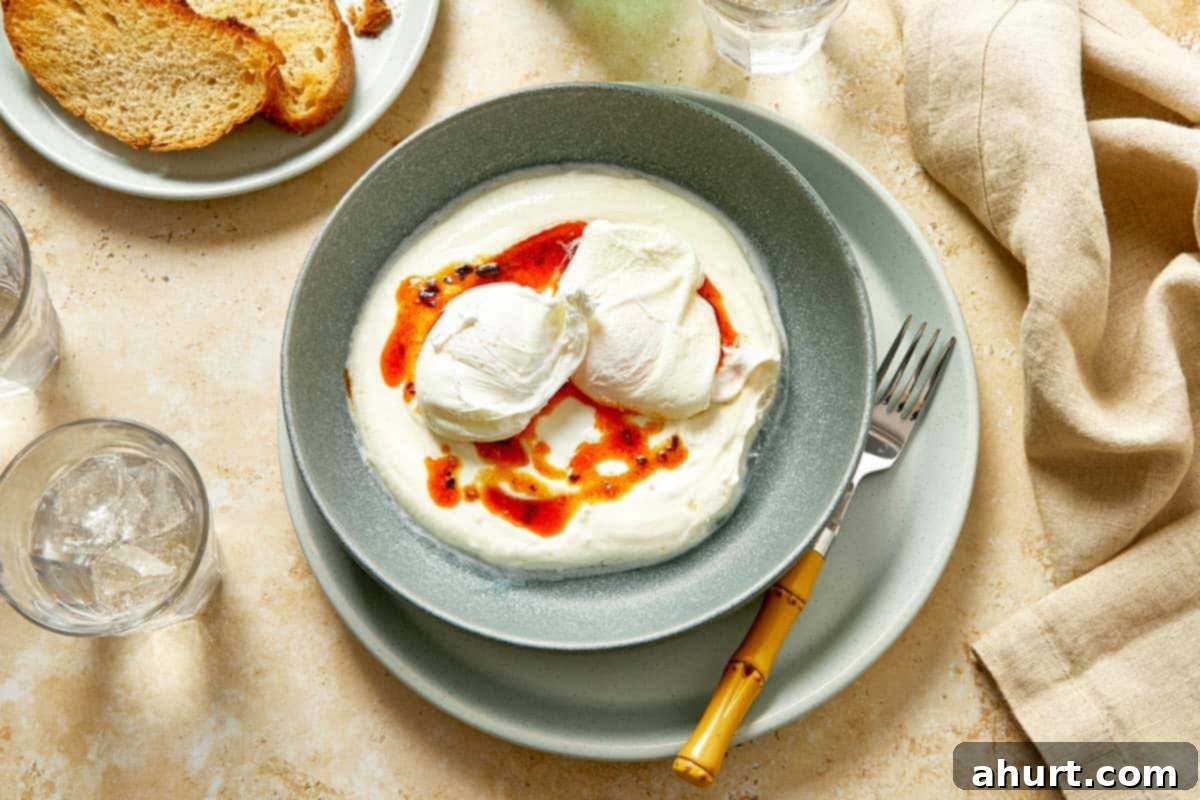 Cilbir Turkish Eggs 8 Poached eggs placed over yogurt and chili butter.