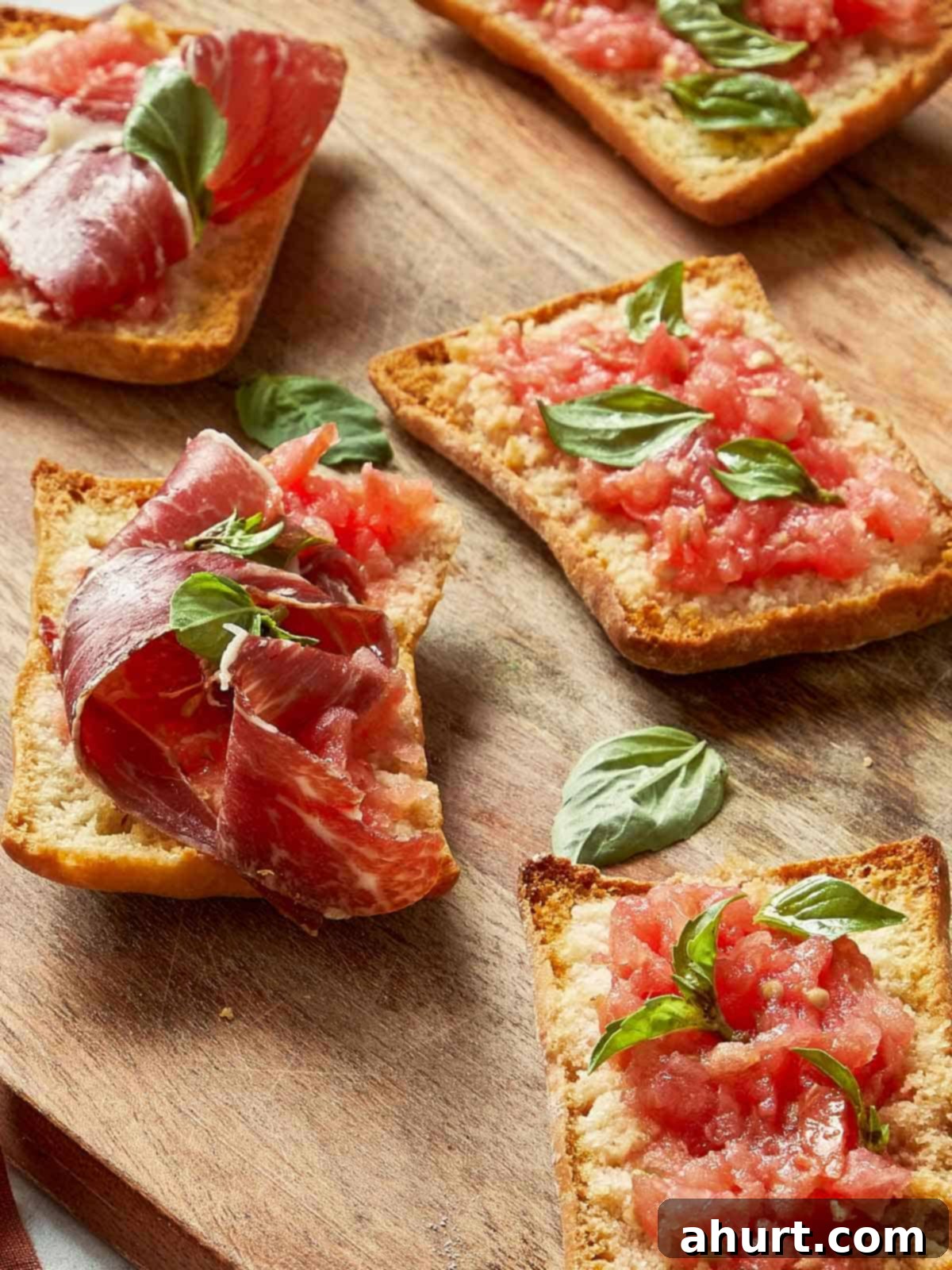 Spanish Tomato Pan Coca 14 Toasted tomato bread slices topped with grated tomato, fresh basil, and Jamón Ibérico on a rustic wooden board.