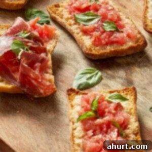 Spanish Tomato Pan Coca 15 Crispy Pan Coca topped with grated tomato, fresh basil, and slices of Jamón Ibérico on a wooden board