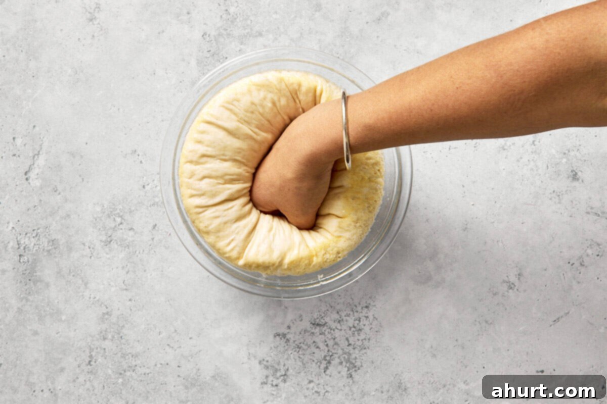 Spanish Tomato Pan Coca 8 Hand punching down risen dough to release air after first proof.