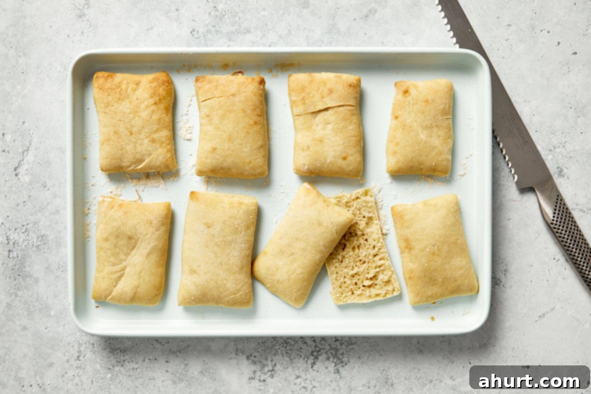 Spanish Tomato Pan Coca 10 Crispy baked bread sliced open and rubbed with garlic on a baking tray.