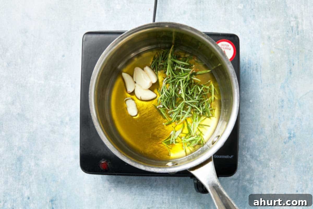 Effortless Homemade Focaccia 14 Olive oil infused with rosemary and garlic heating in a small saucepan, preparing the aromatic topping.