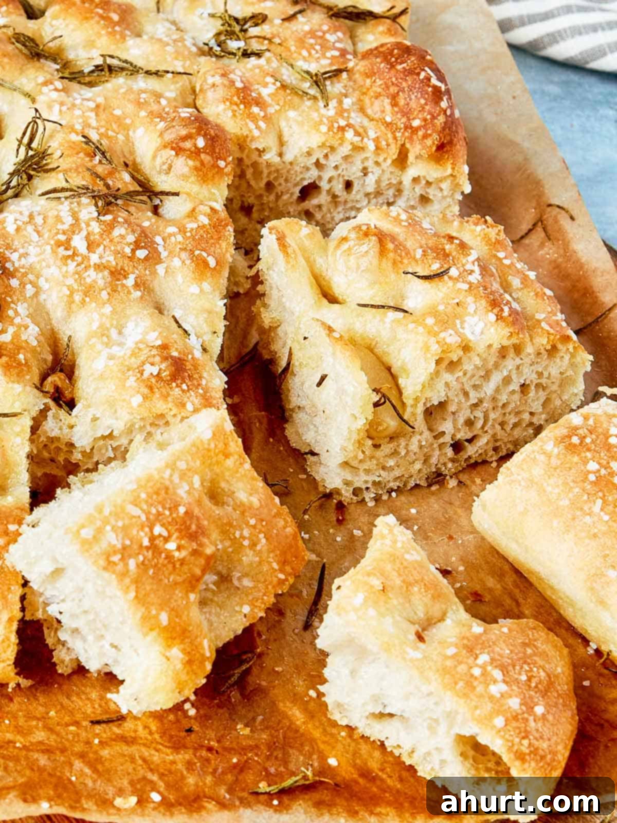 Effortless Homemade Focaccia 18 Close-up of sliced focaccia showing airy texture, crispy edges, and rosemary on top.