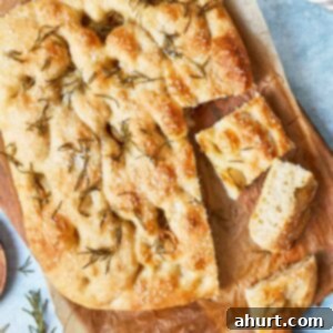 Effortless Homemade Focaccia 19 Sliced focaccia showing airy texture, crispy edges, and rosemary on top, ready to serve.
