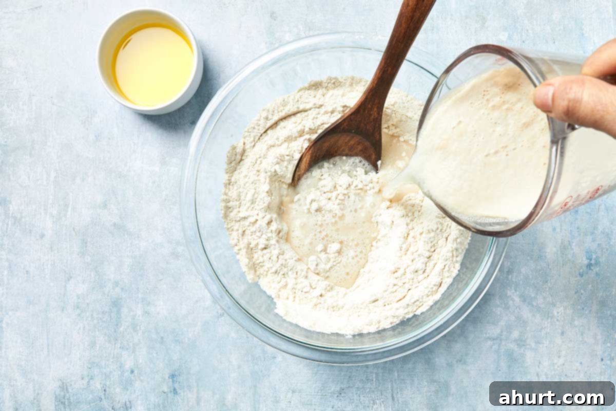 Effortless Homemade Focaccia 6 Yeast mixture being poured into flour to form dough, emphasizing the initial combining step.