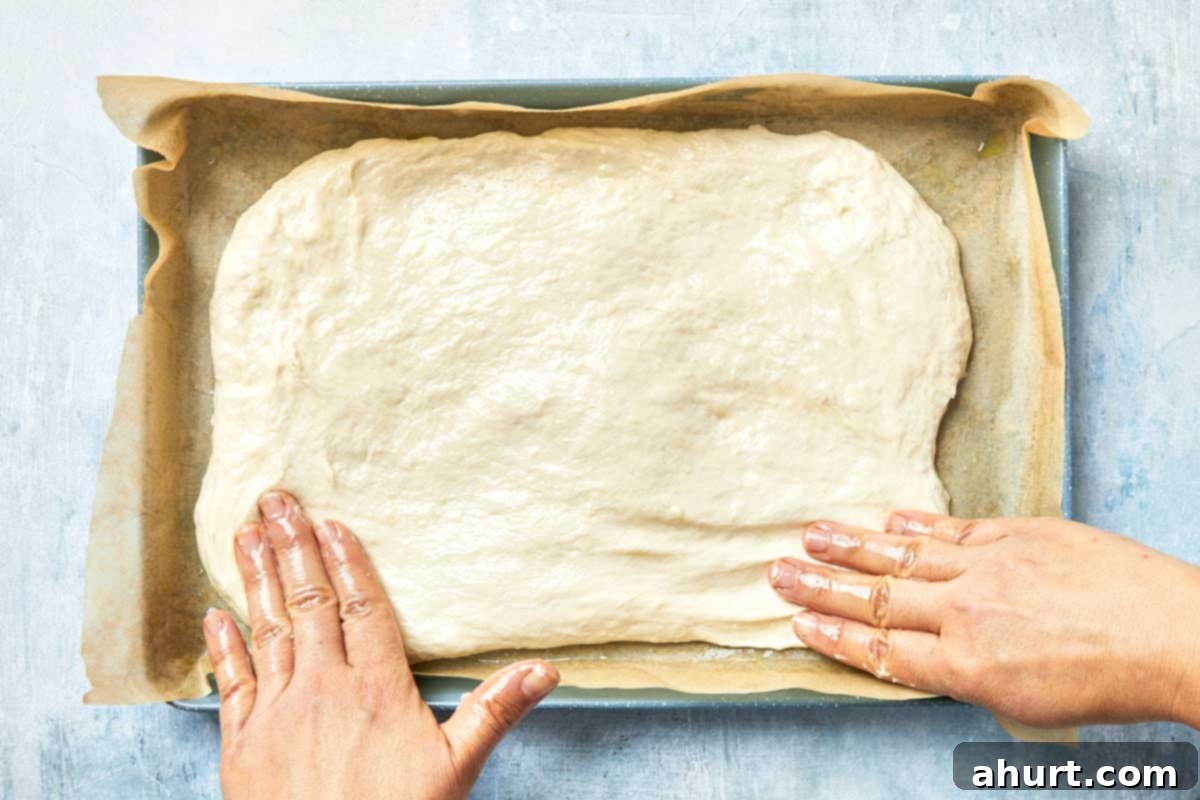 Effortless Homemade Focaccia 9 Dough placed into the prepared pan and gently pressed out with oiled fingers.