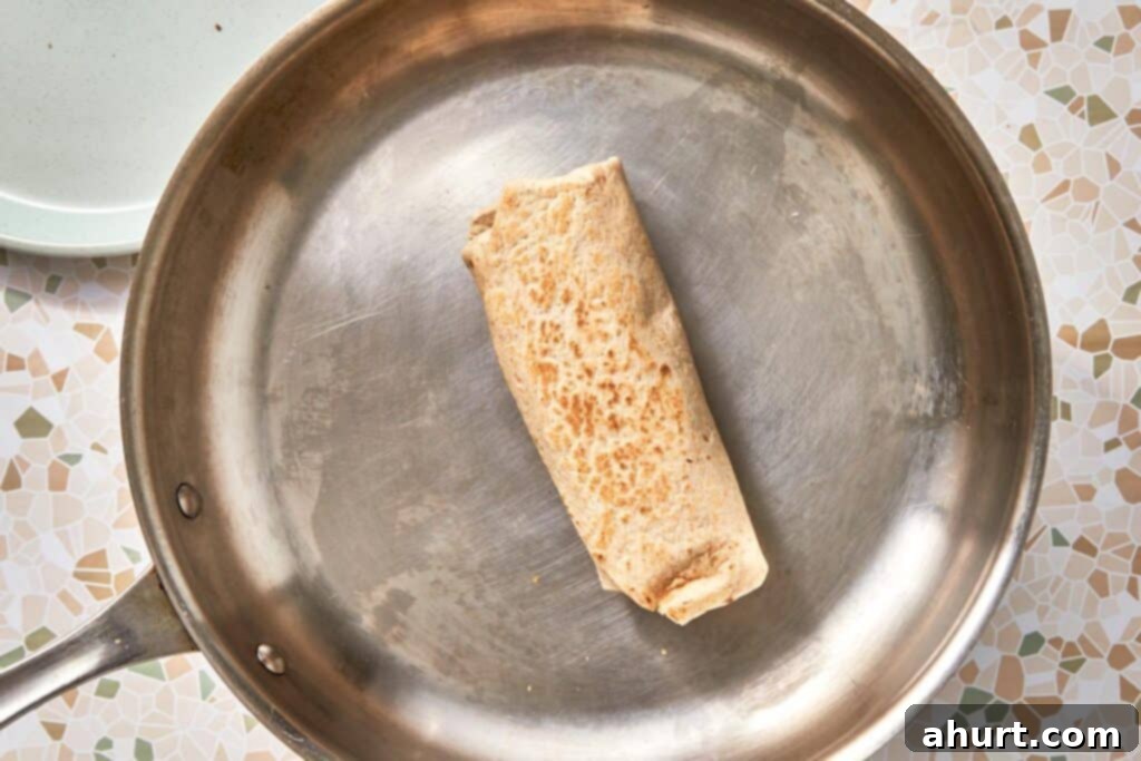 Signature Crispy Caesar Wrap 17 Toasting a Crispy Chicken Caesar Wrap in a hot skillet.