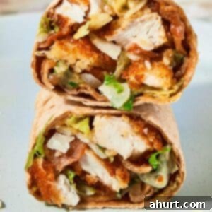 Signature Crispy Caesar Wrap 19 A close-up of a Crispy Chicken Caesar Wrap, cut in half to show the delicious filling.