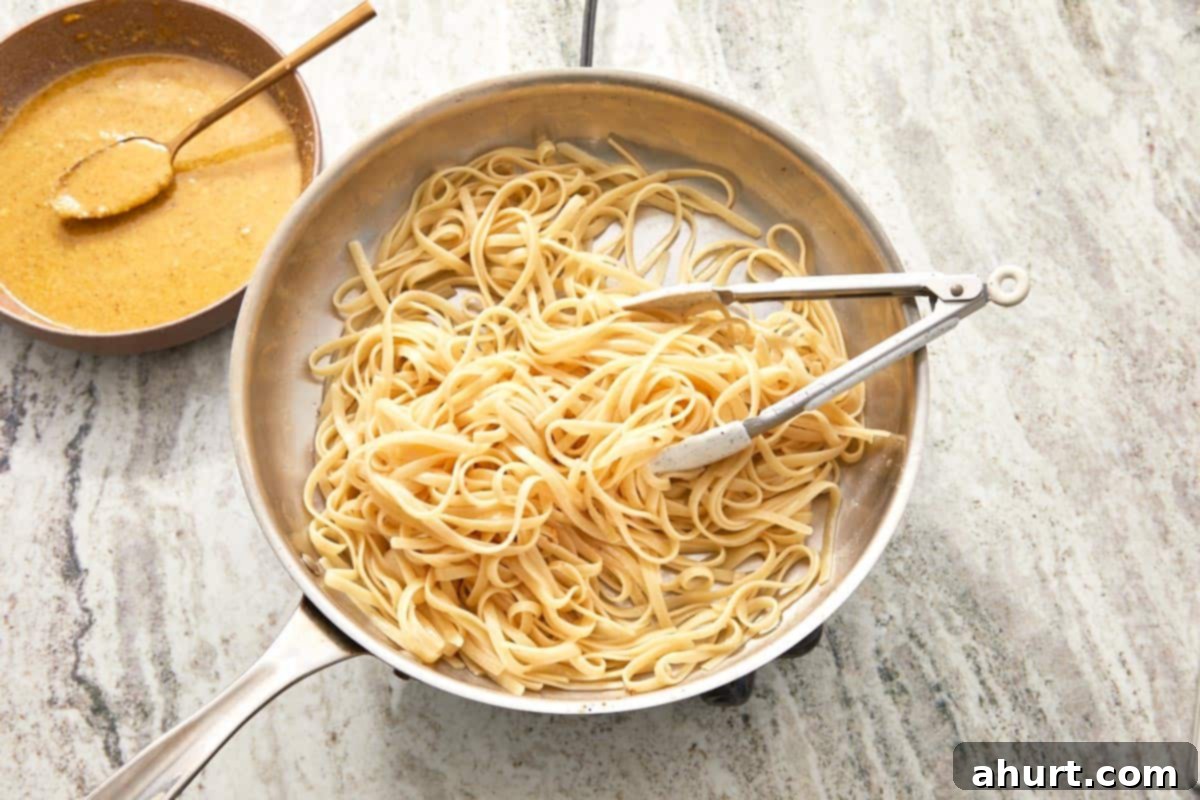 Velvet Carbonara Bliss 8 Cooked linguini in a skillet next to a bowl of carbonara