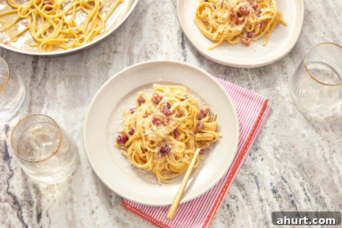 Velvet Carbonara Bliss 9 A plate of finished pasta carbonara on a red-striped napkin, topped with crispy pancetta and extra cheese.