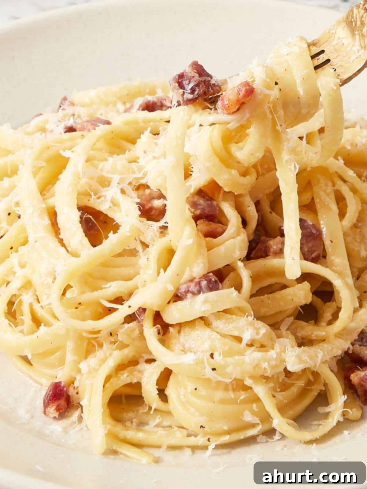 Velvet Carbonara Bliss 10 Close-up of creamy carbonara pasta twirled on a fork with crispy pancetta and freshly grated Pecorino Romano.