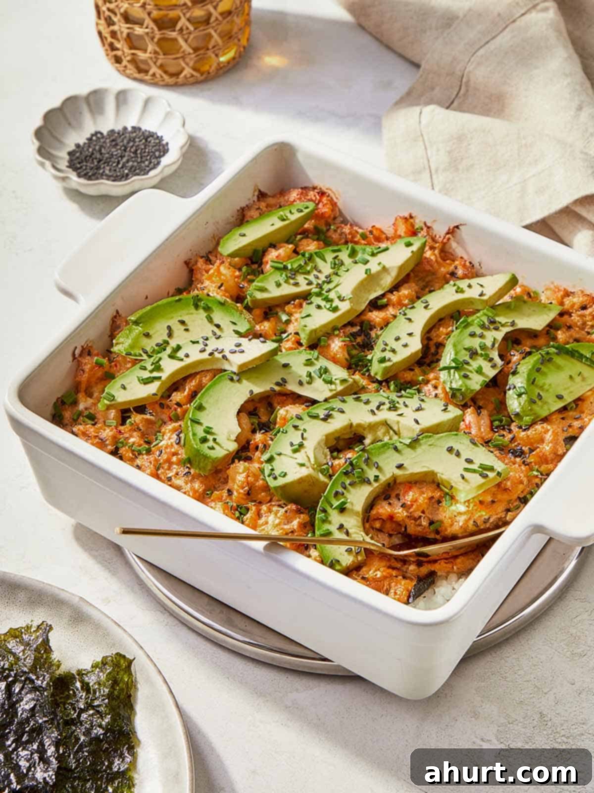 Easy At-Home Sushi Bake 2 A serving of Sushi Bake garnished with creamy avocado, highlighting the dish's vibrant and inviting appearance.