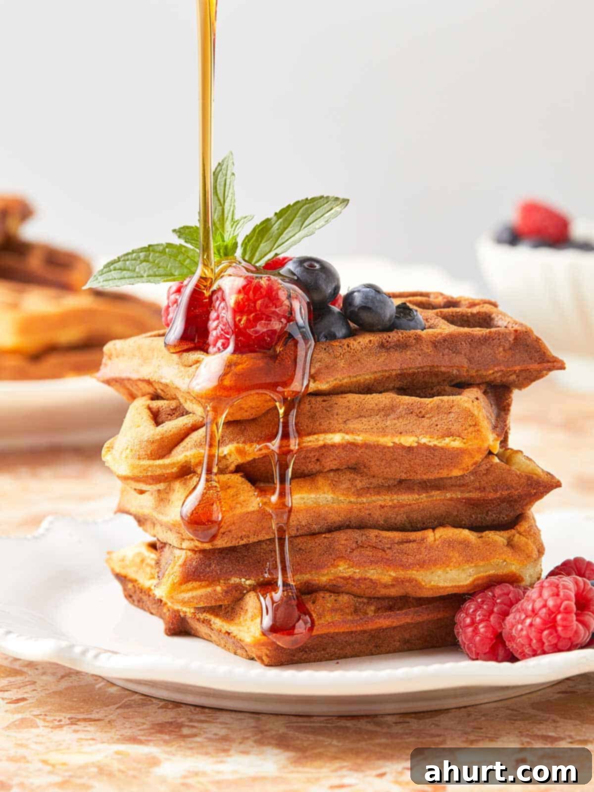 The Ultimate Paffles Waffle Pancake Perfection 10 A stack of golden Wancakes with syrup cascading over them.