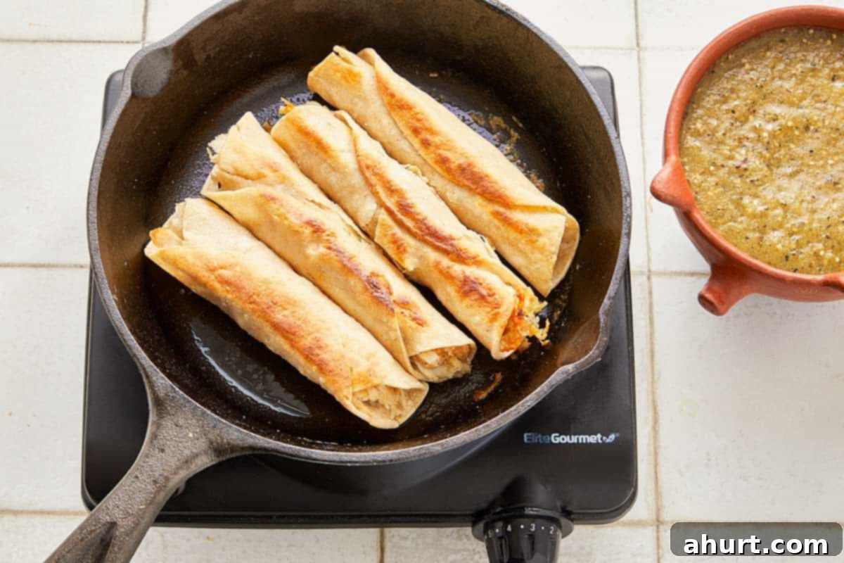 Green Enchiladas 7 A pan filled with multiple tortillas, heating up for browning enchiladas.
