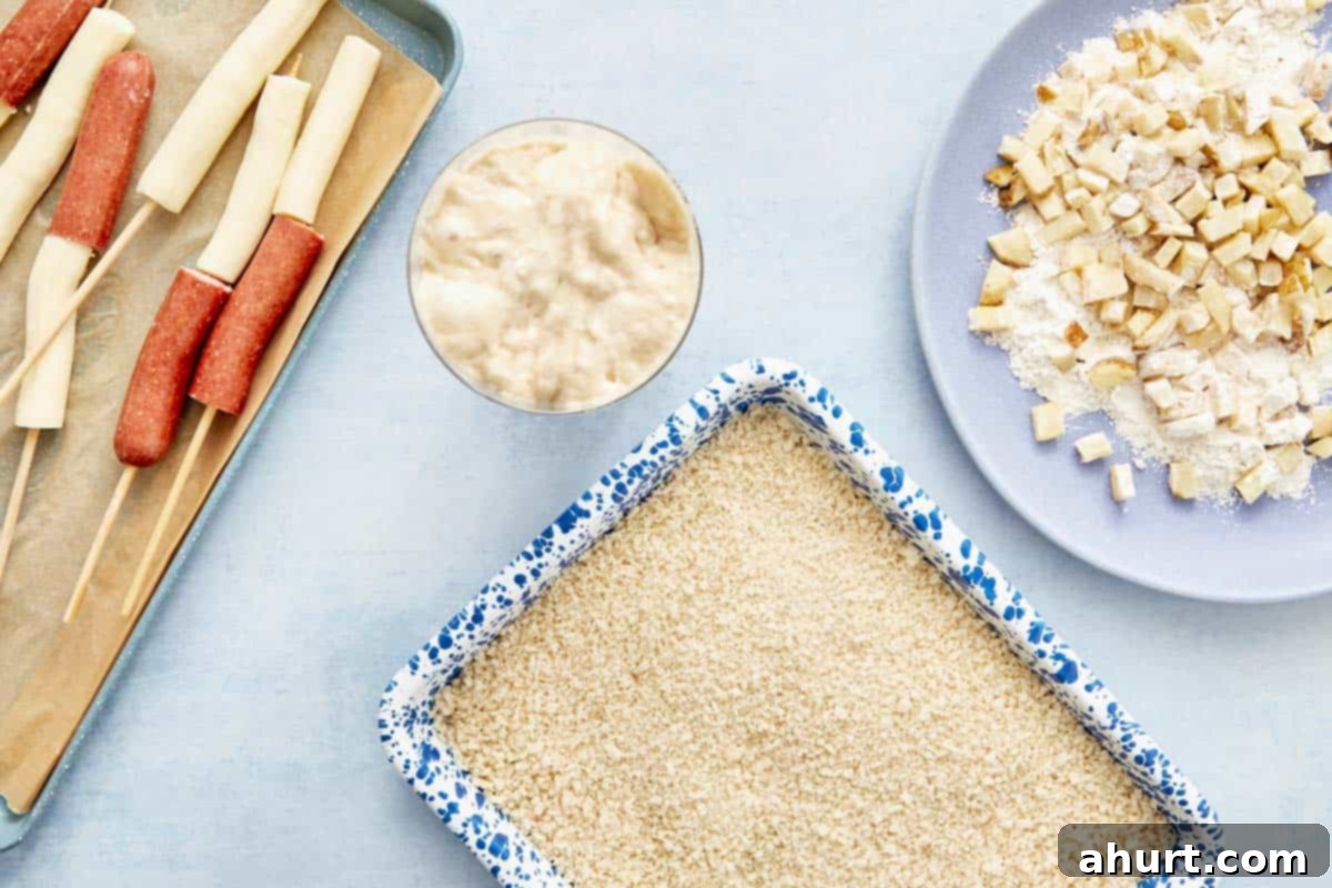 Easy Korean Corn Dogs A Snack Sensation 6 Prep station with batter, panko breadcrumbs, and diced fries ready for coating corn dogs.