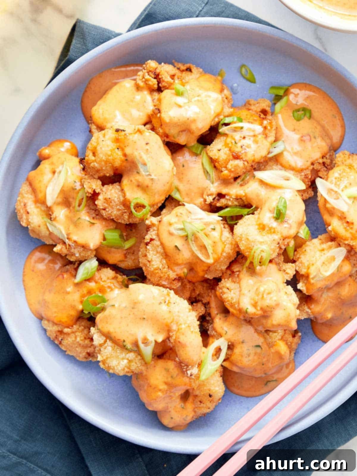 Dynamite Shrimp 2 Crispy golden Bang Bang Shrimp drizzled generously with creamy spicy Bang Bang sauce and garnished with fresh green onions for a vibrant finish.