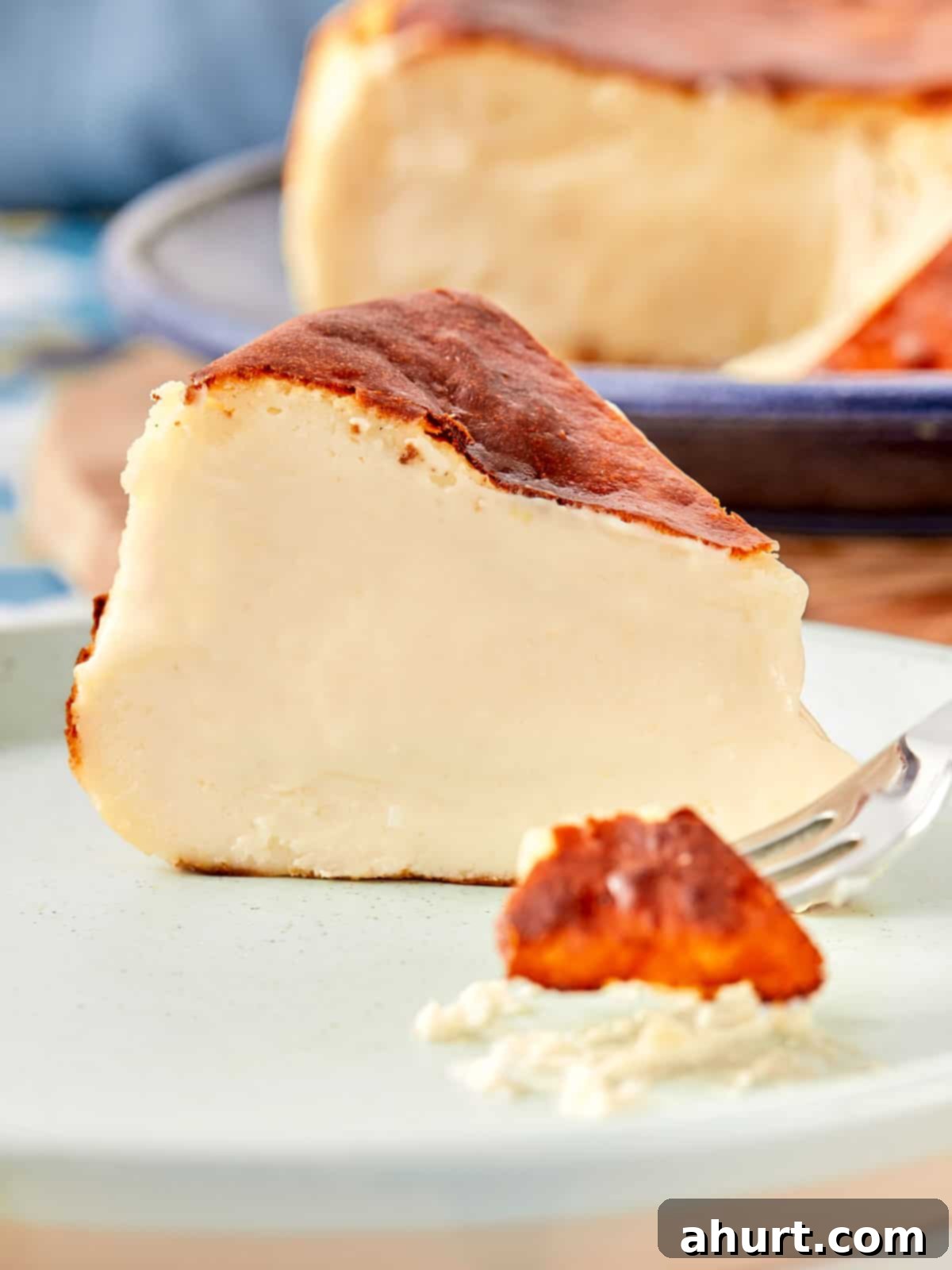 Burnt Basque Cheesecake 10 Close-up slice of Basque cheesecake with creamy center and caramelized top on a blue plate