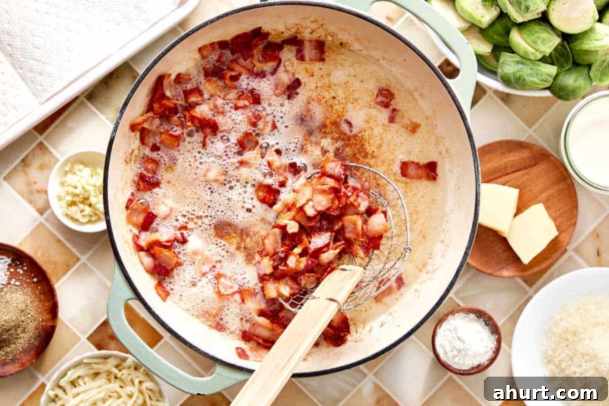 Smoky Bacon Brussels 5 Crispy, rendered bacon cooking in a skillet, creating flavorful drippings, before being removed from the pan.