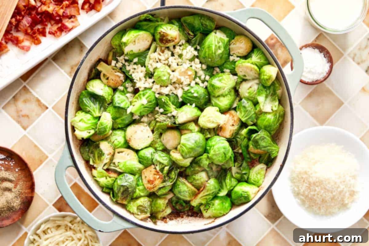 Smoky Bacon Brussels 8 Sautéed Brussels sprouts browning in a skillet with freshly chopped garlic added, creating a fragrant aroma.