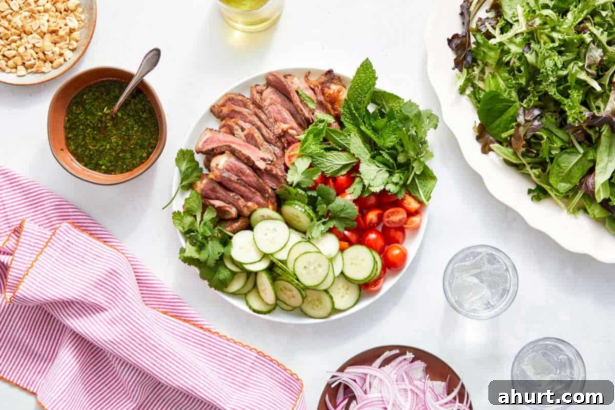 Vibrant Thai Beef Salad 11 Salad components including sliced steak, cucumber, tomatoes, herbs, and dressing, arranged before tossing.